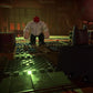 Character in a dark, industrial setting with a red mask and white shirt.